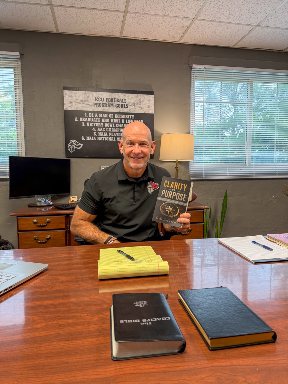 Coach Jason Aubry holding Clarity of Purpose in his office